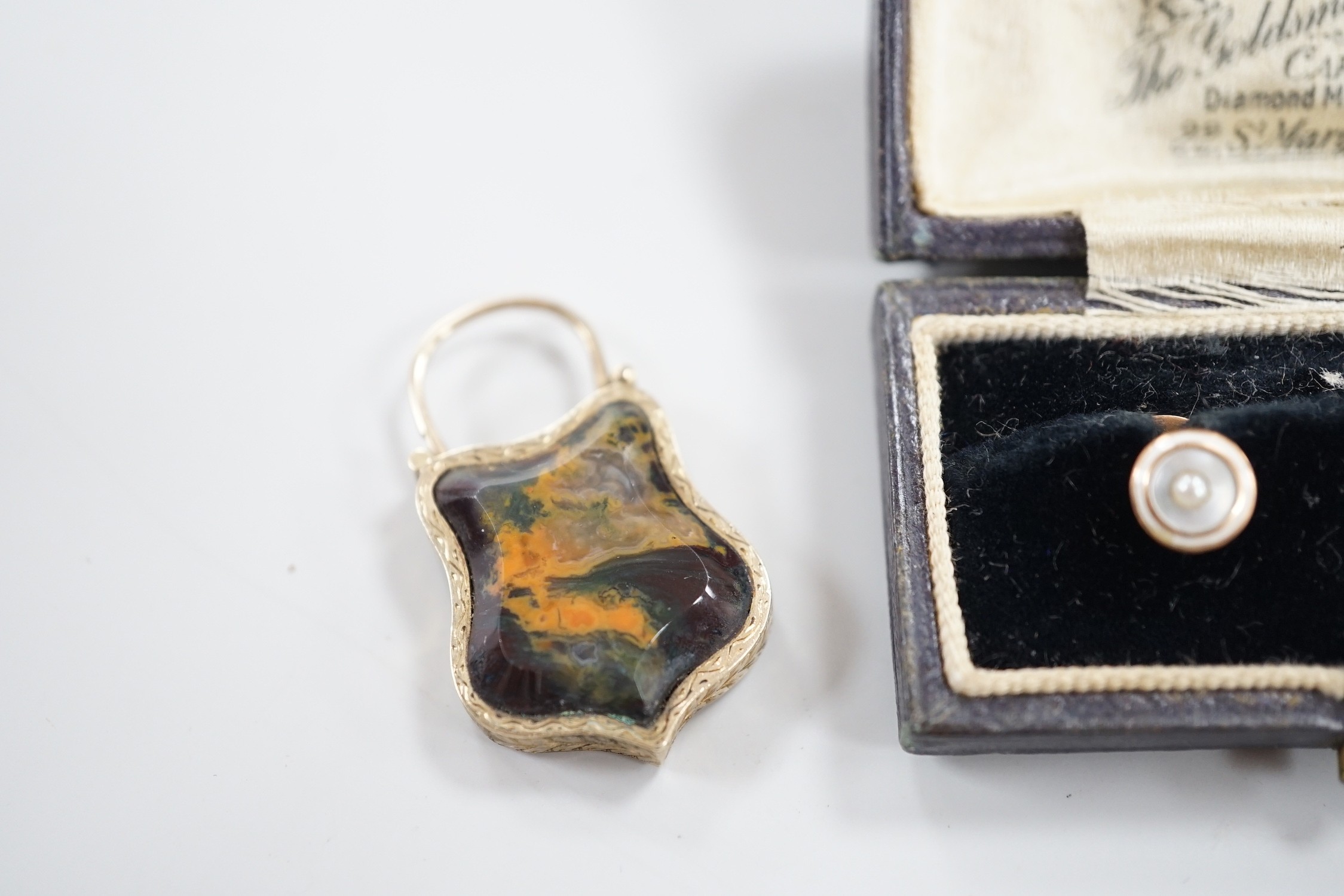 A late Victorian yellow metal and Scottish hardstone set padlock charm, with glazed panel verso, 34mm and a pair of 9ct and mother of pearl studs.
